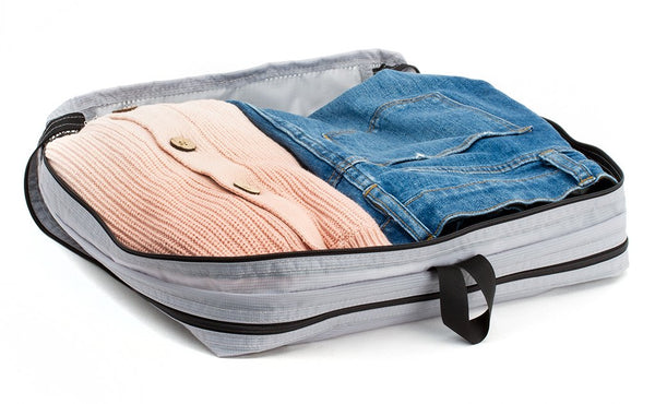 A change of clothes folded in a Northwest Sky (light grey) Aether Large Laundry Aeronaut 45 Packing Cube.